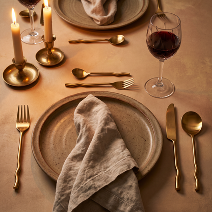 Emma brass flatware in a candlelit dinner place setting