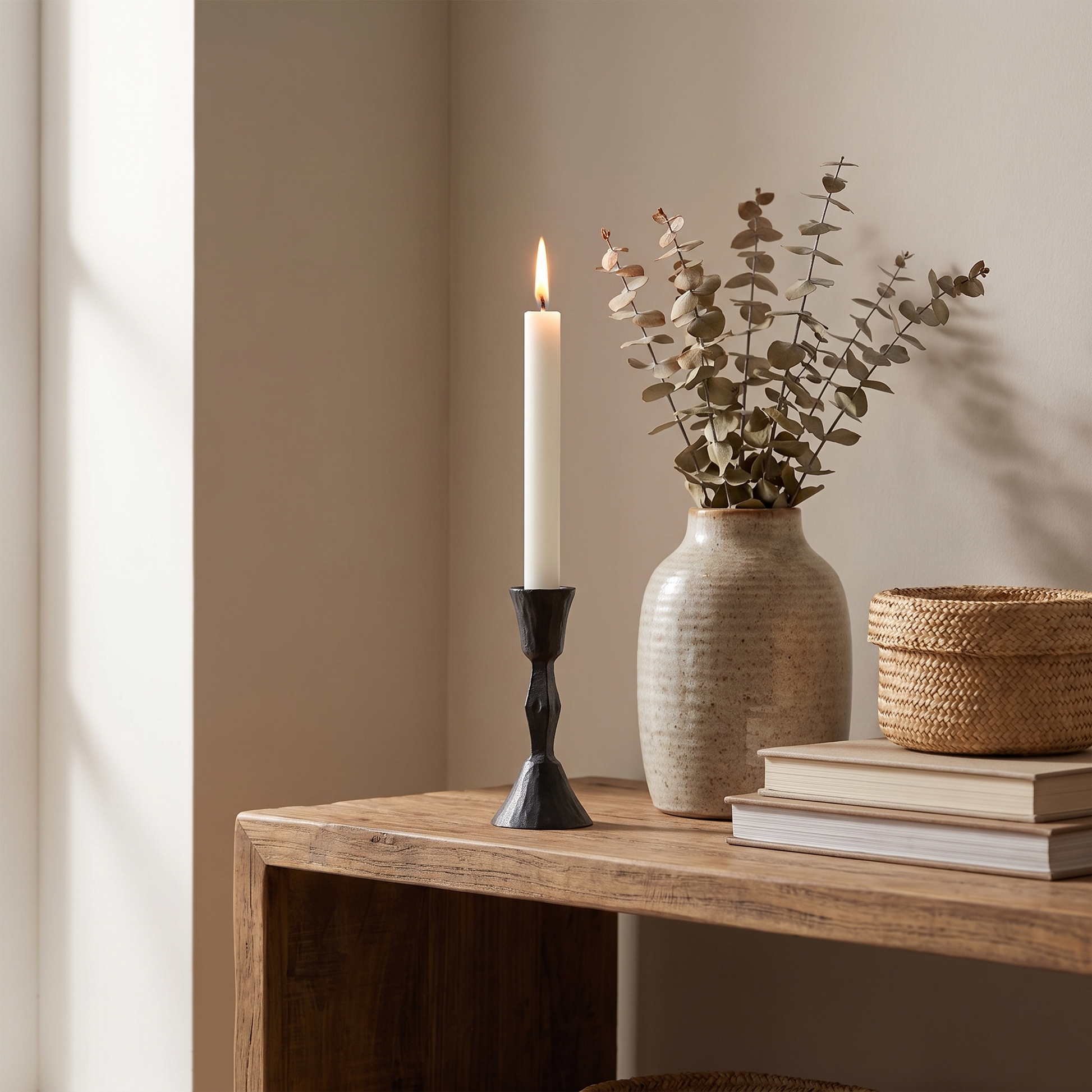 Low diamond iron candle stand styled on an open wooden shelf with a lit candle