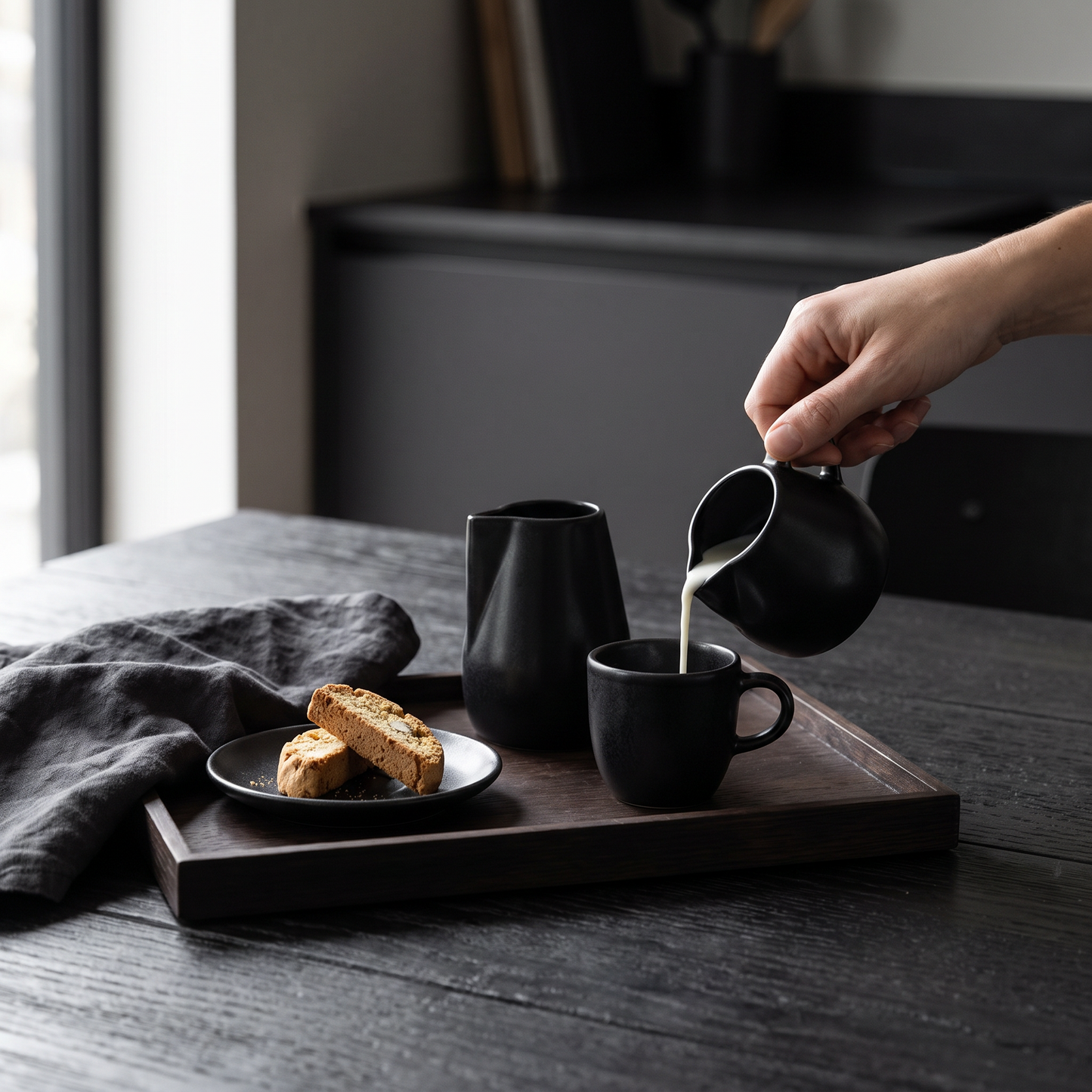 Black Novah creamer set on a morning coffee tray with espresso and biscuits