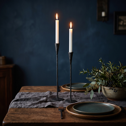 Phoenix hand-forged iron candle stands as a pair with lit tapers on a dinner table