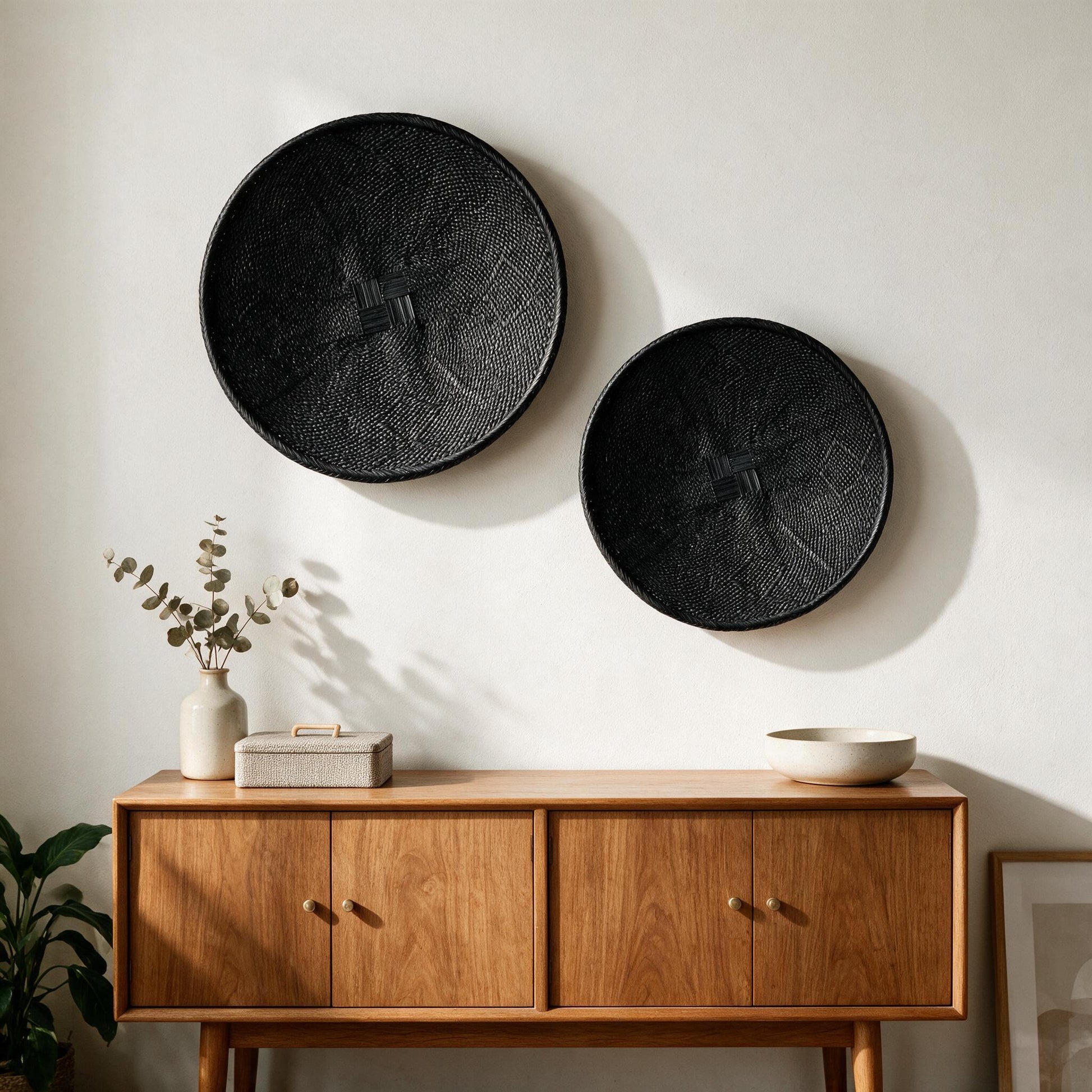 Hand-painted black Binga flat baskets, set of two, on a wall