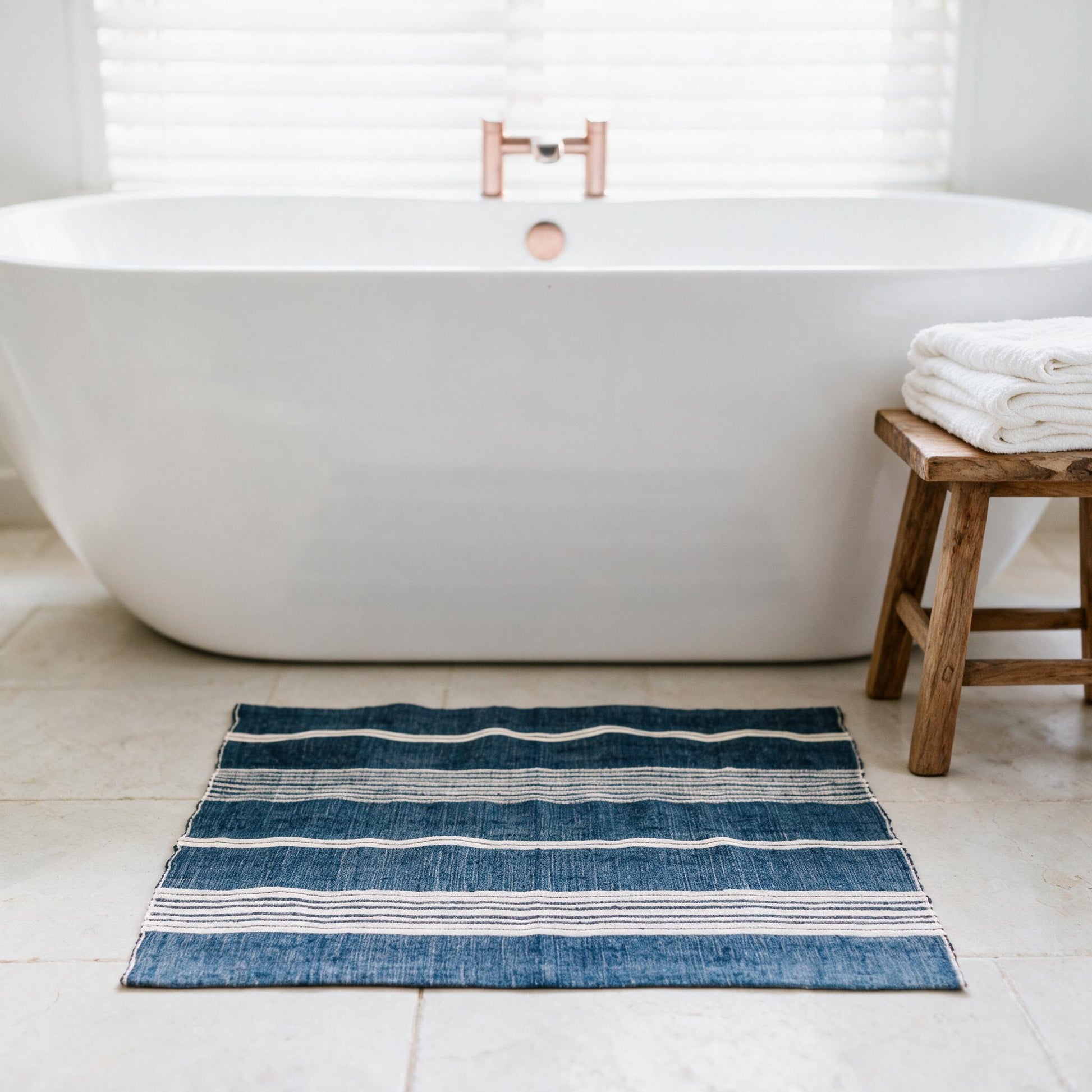 Aden cotton bath mat beside a freestanding tub