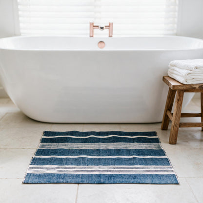 Aden cotton bath mat beside a freestanding tub