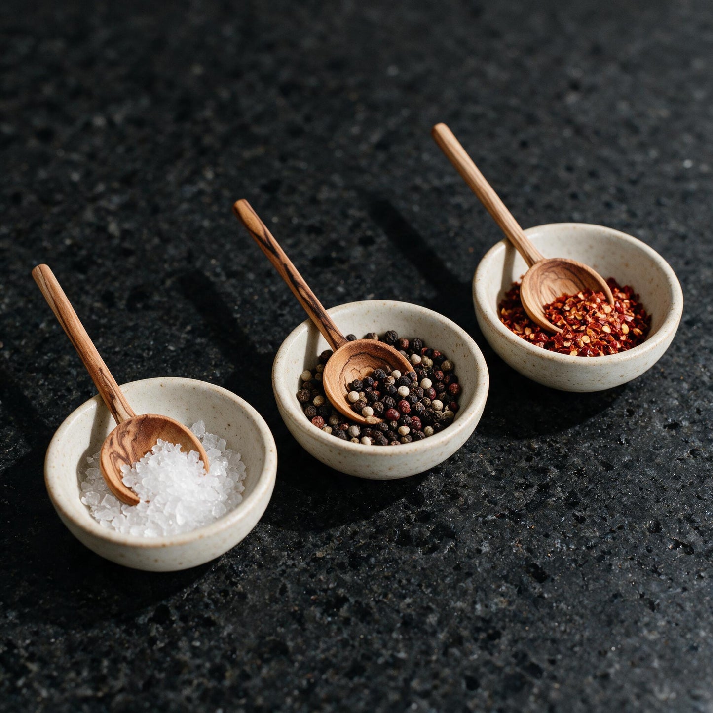 Olive wood condiment spoons in spice bowls