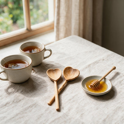 Olive wood heart teaspoon pair beside tea